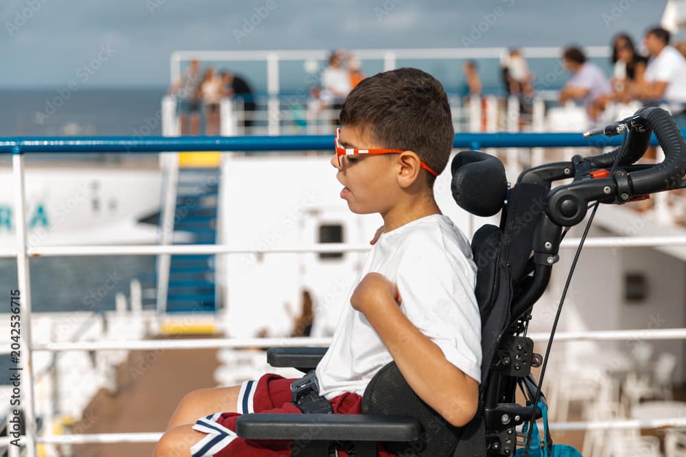 A young boy enjoys the sea view from the deck of a ship.